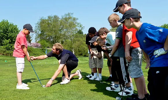 Man teaching children how to golf