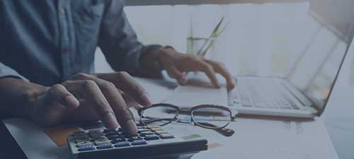 business man or lawyer accountant working on accounts using a calculator and laptop computer in his office