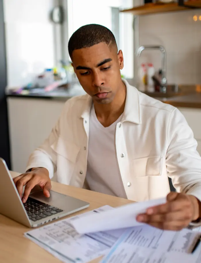 man on computer reviewing papers